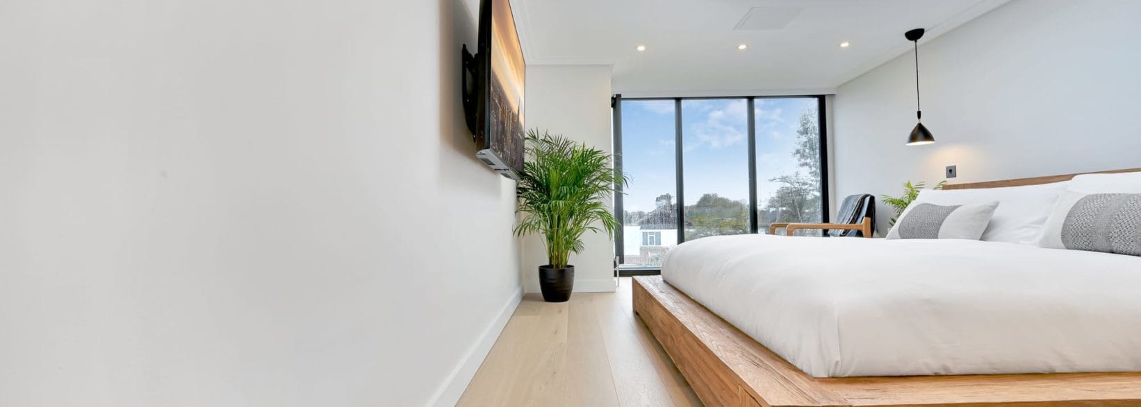 bedroom with french windows, in a Hip to gable & dormer loft conversion at a home in Hither Green, South East London, SE12