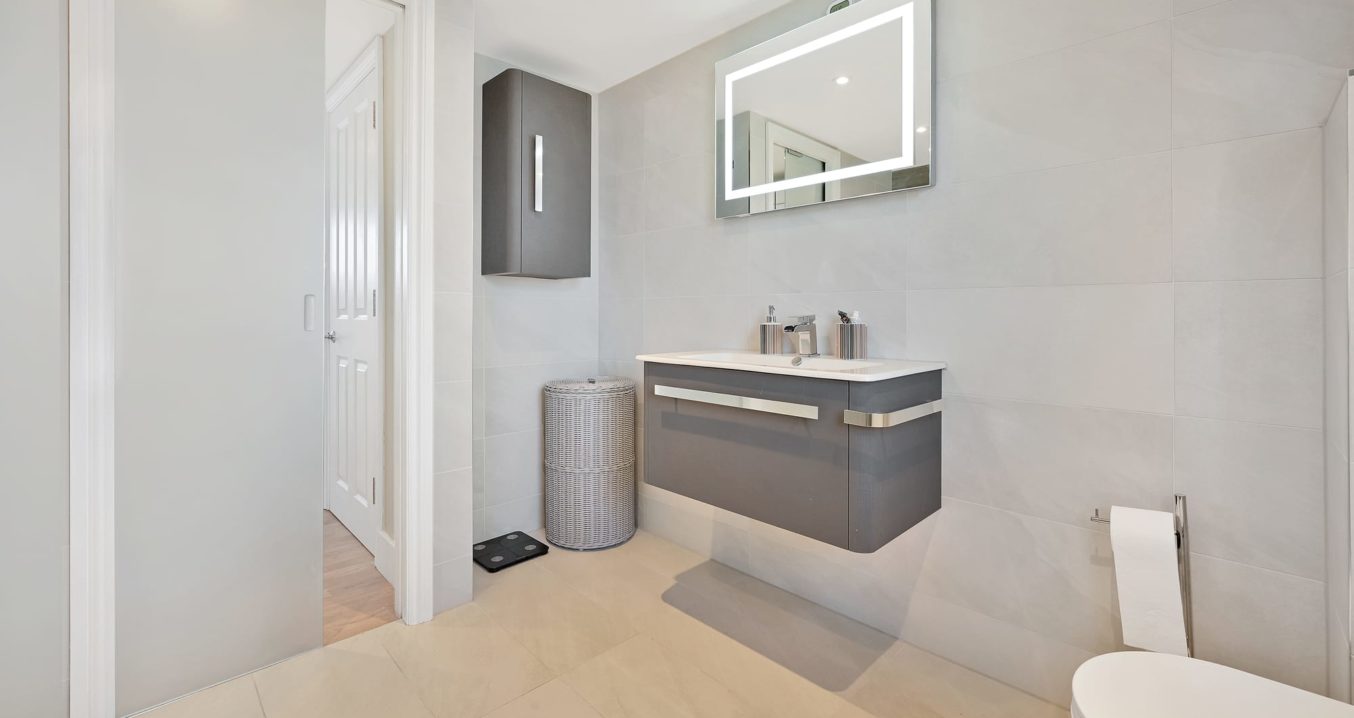 contemporary grey bathroom in an L-Shaped Dormer, at a home in Norwood South East London, SE27