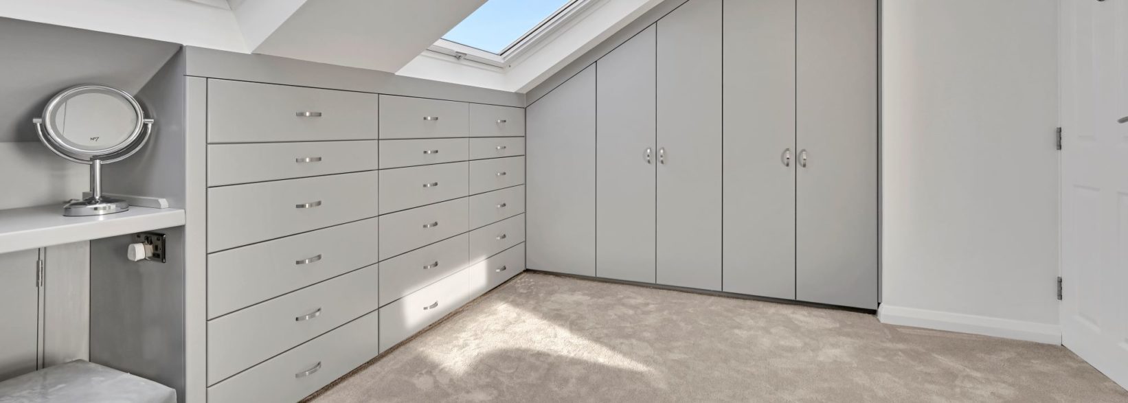 Grey bedroom in L shaped dormer loft conversion. Spacious and calming interior. Project in Hornchurch, RM14 by experts Absolute Lofts