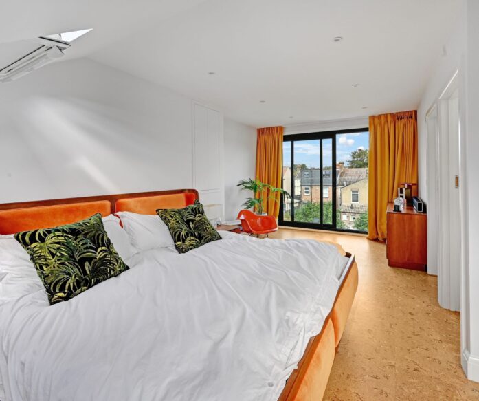 Large bedroom with sliding doors leading onto balcony. Rear dormer loft conversion in E9 London