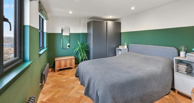 Green and grey colour scheme gives calming feel to large master bedroom in impressive loft conversion at property in Billericay CM12