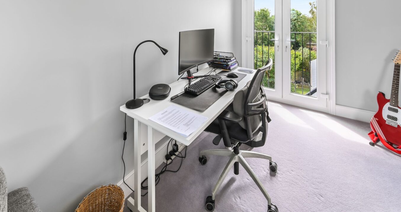 Loft conversion study room in Barnet North London with Juliet balcony, French doors, white desk workspace, ergonomic chair, and garden views