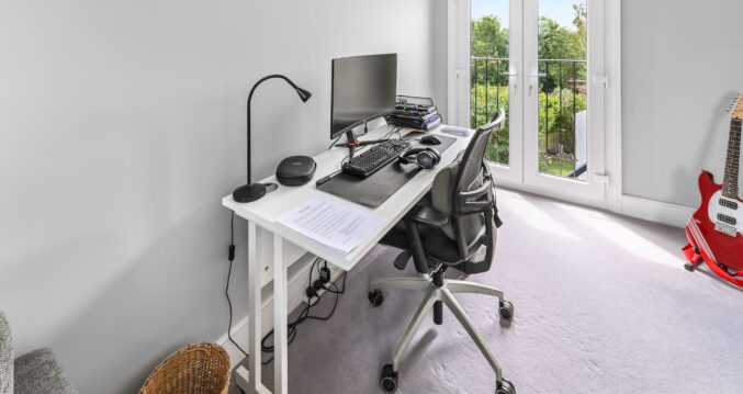Loft conversion study room in Barnet North London with Juliet balcony, French doors, white desk workspace, ergonomic chair, and garden views