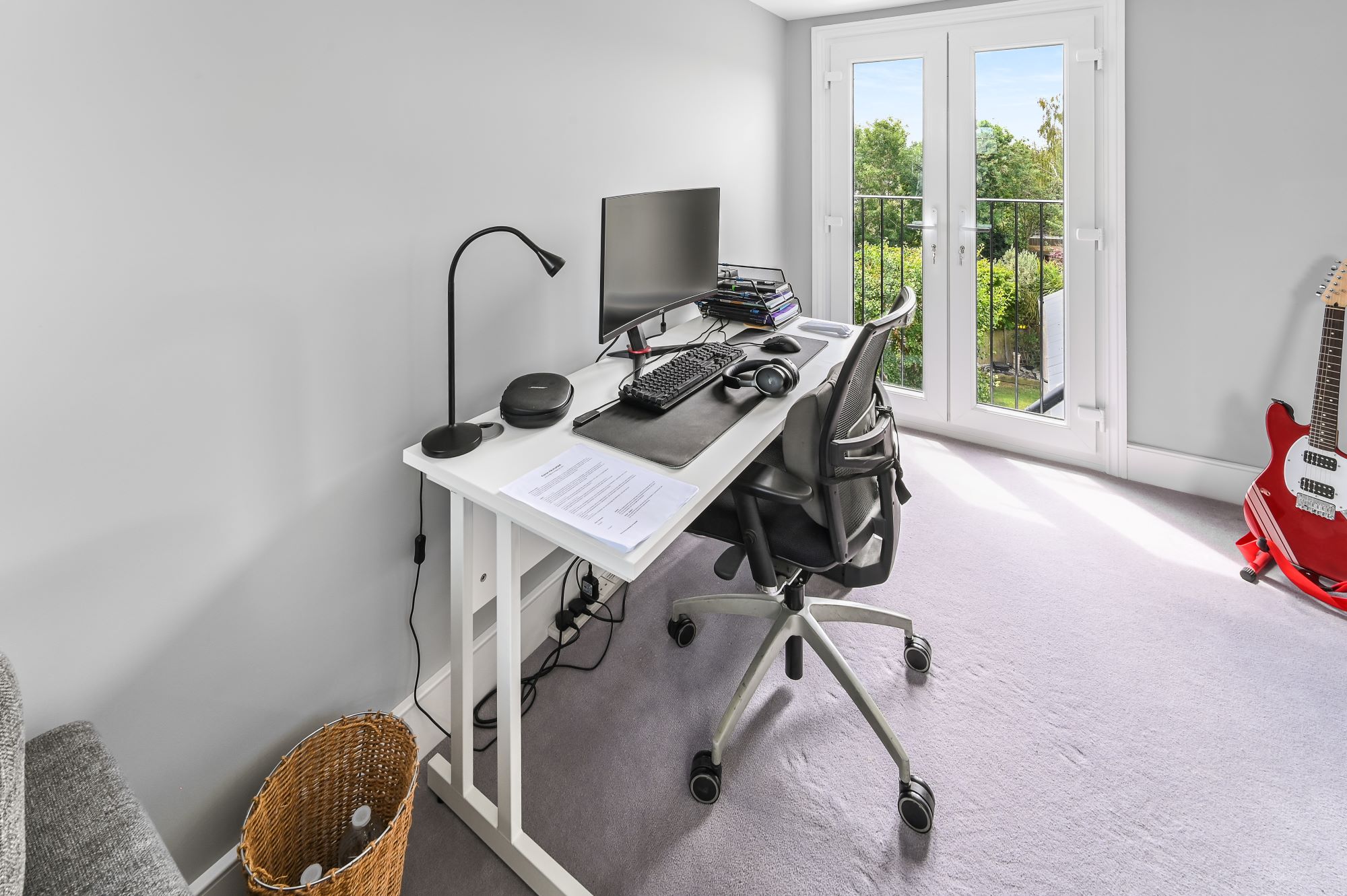 Loft conversion study room in Barnet North London with Juliet balcony, French doors, white desk workspace, ergonomic chair, and garden views