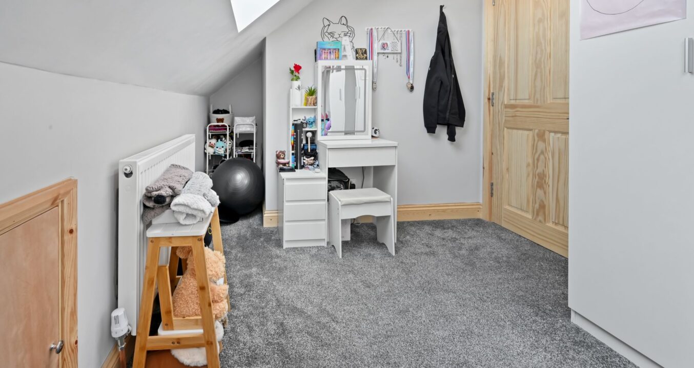 Light-filled children’s play and study space with white vanity desk, storage, and large skylights in the Woolwich SE18 loft conversion