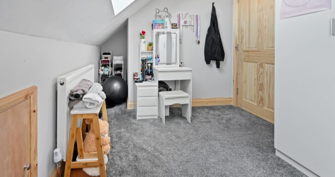 Light-filled children’s play and study space with white vanity desk, storage, and large skylights in the Woolwich SE18 loft conversion