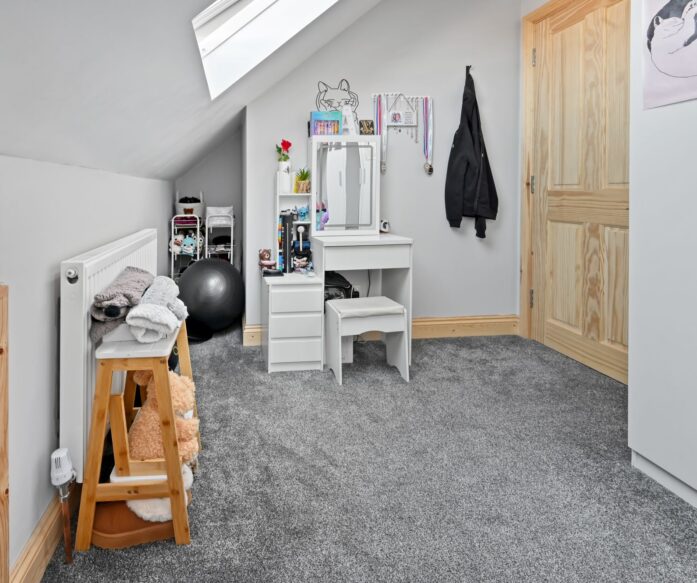 Light-filled children’s play and study space with white vanity desk, storage, and large skylights in the Woolwich SE18 loft conversion