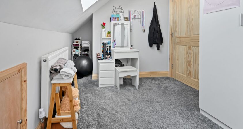 Light-filled children’s play and study space with white vanity desk, storage, and large skylights in the Woolwich SE18 loft conversion