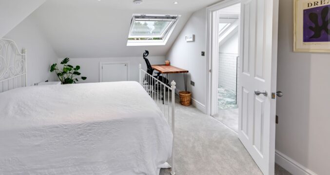 Loft conversion bedroom with compact home office desk and en suite access for Archway loft content