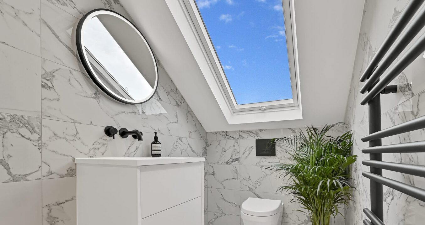 Compact L-shaped dormer loft conversion shower room in Barnet with rooflight Velux window