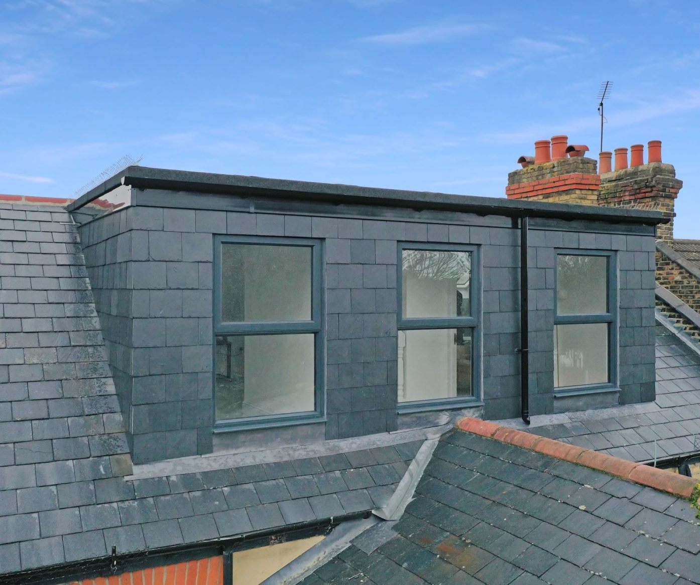Modern dormer loft conversion with new dark slate roof and aluminium windows on a Walthamstow property