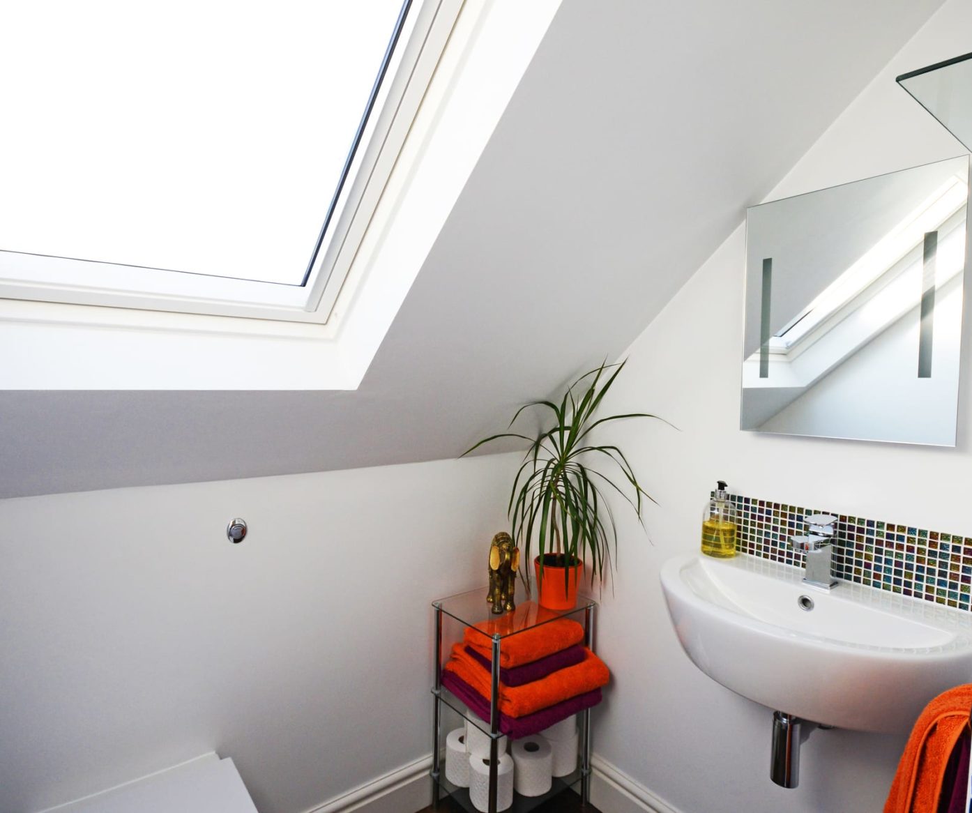 Bright en-suite shower room with large skylight, modern sink and green tiled walls in Walthamstow loft conversion