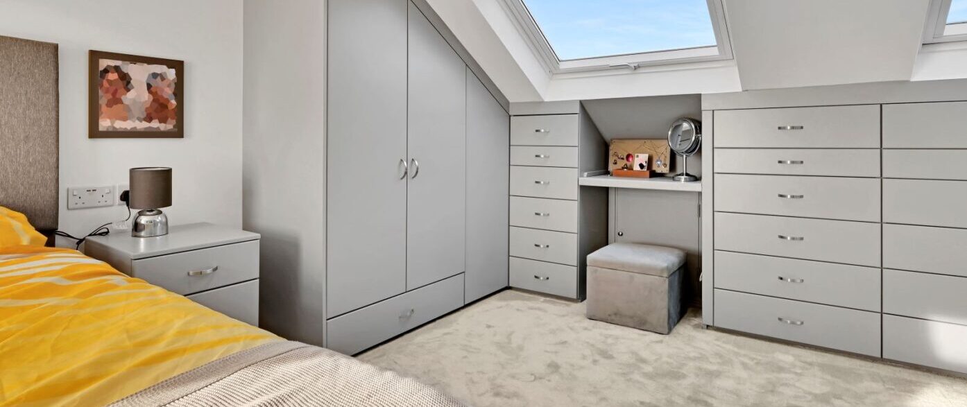 Modern grey fitted bedroom with large wardrobes and skylight in a Walthamstow loft conversion