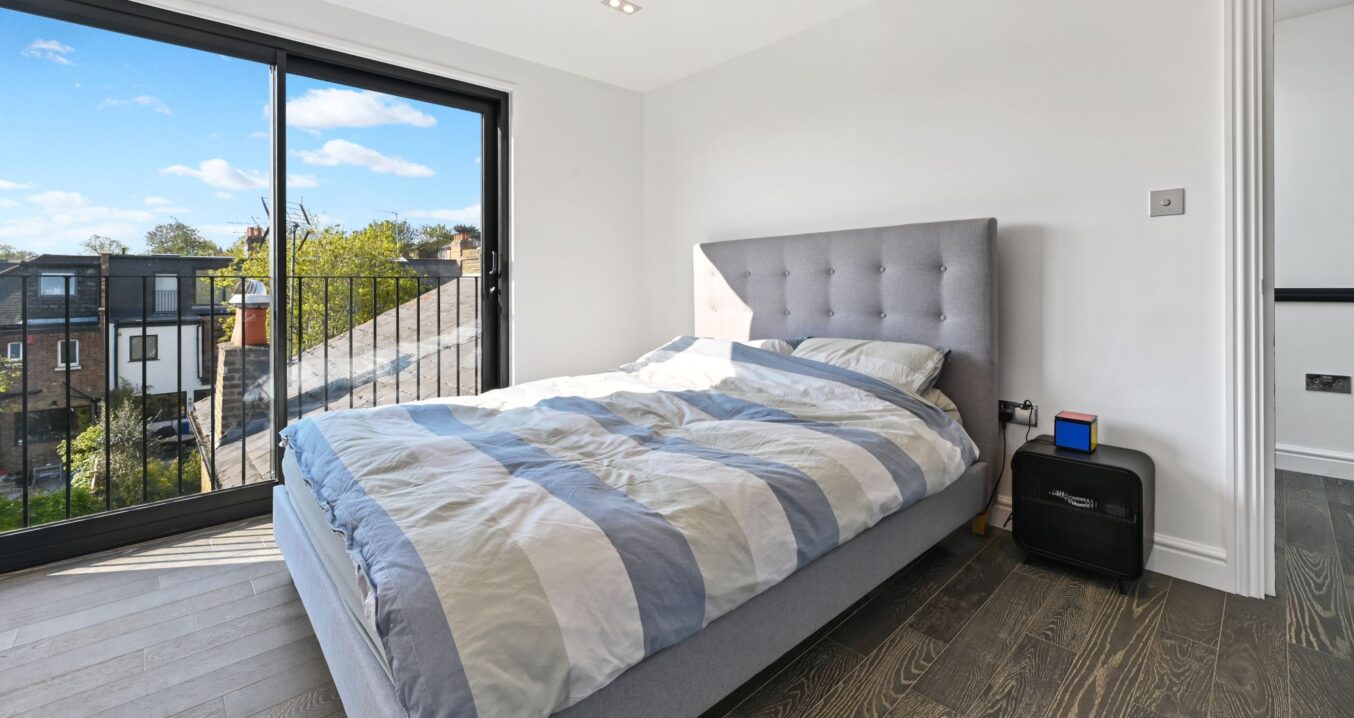 Hip to gable loft bedroom with large glazed doors and modern finishes, suitable for loft conversion homes in Norwood SE19.