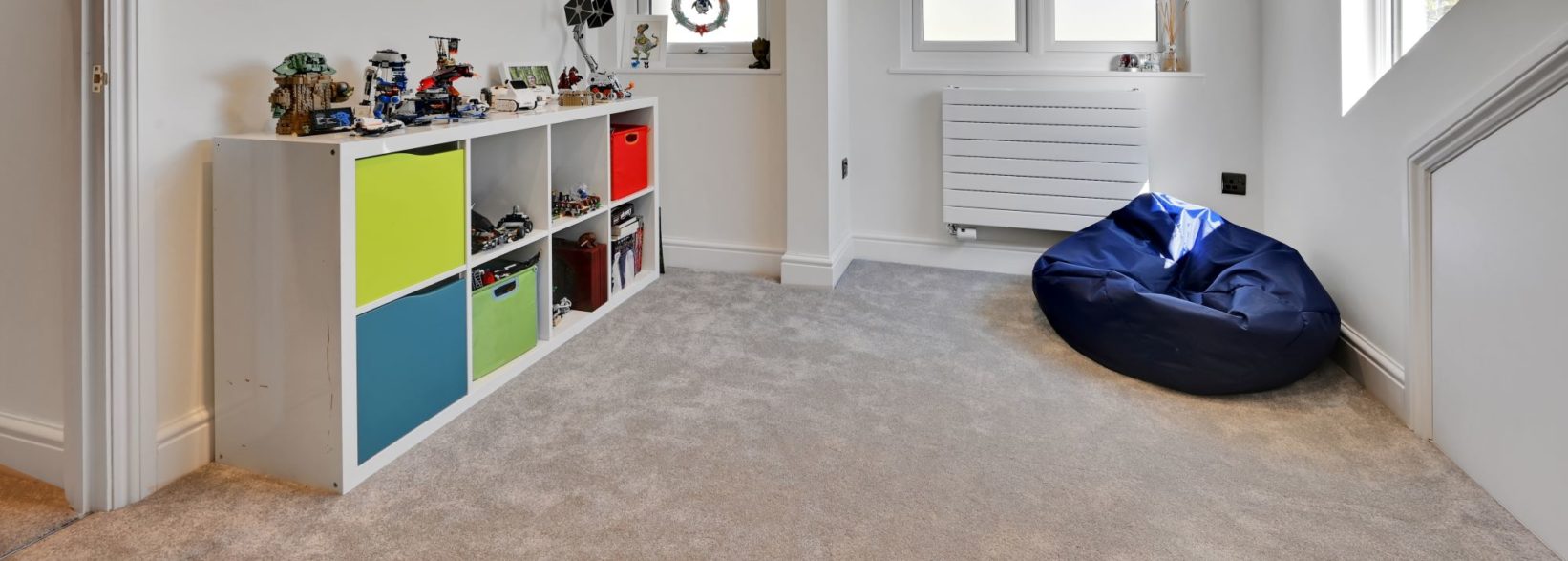 Kids loft playroom Leytonstone E11 with white storage units and beanbag