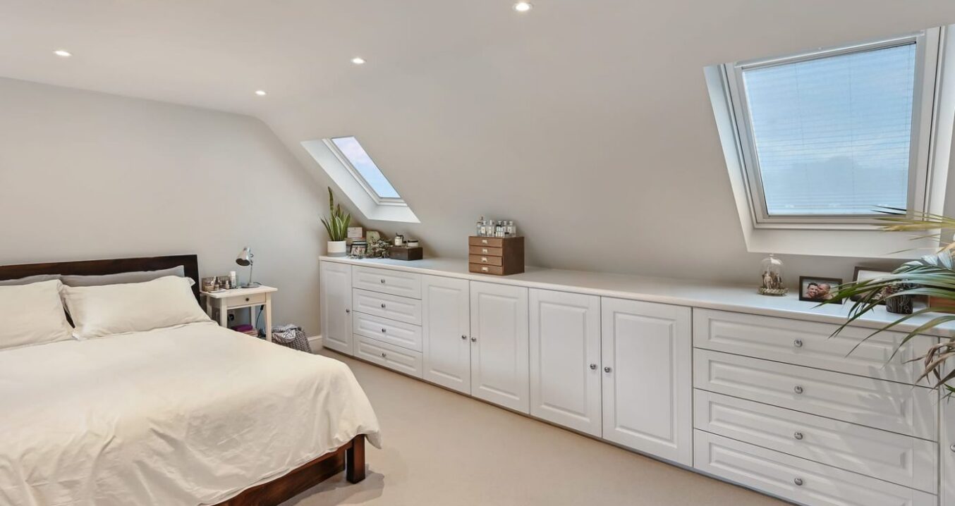 L shaped dormer loft bedroom with fitted cupboards and roof windows, suitable for loft conversion projects in Norwood SE27.