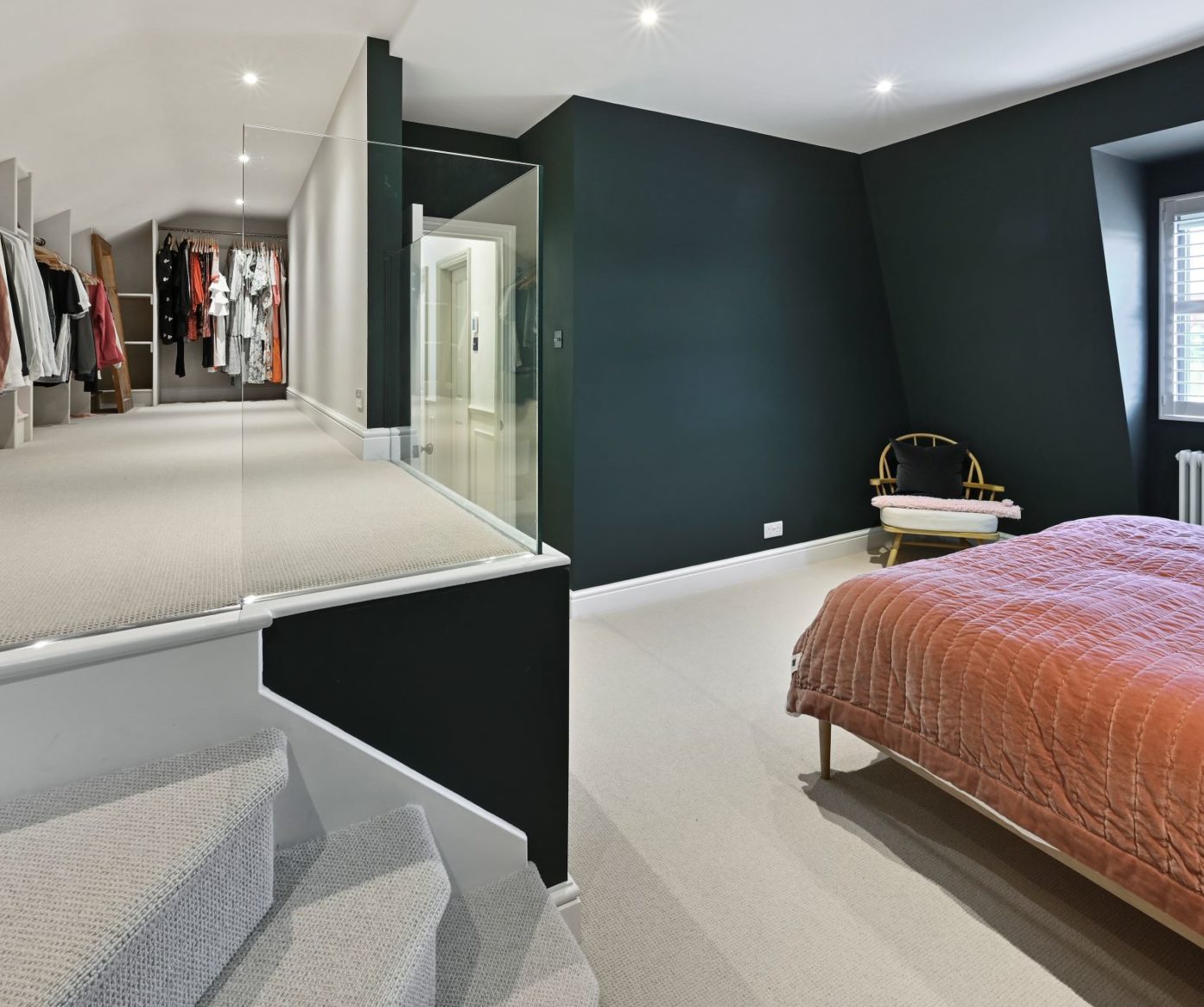 Bedroom loft conversion in Beckenham BR3 with dark feature walls, glass balustrade and dressing area