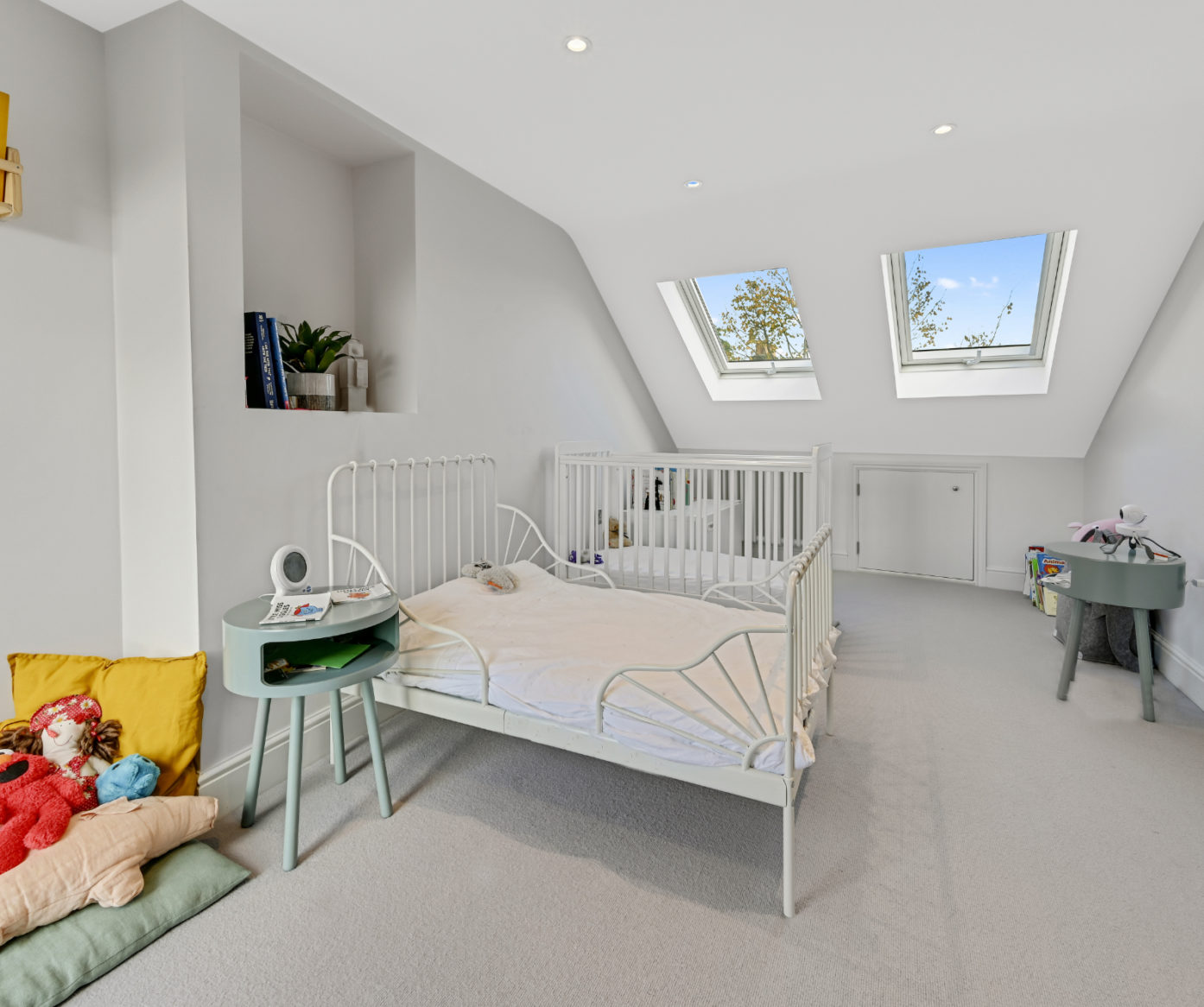 Cot room in a Beckenham BR3 loft conversion with two roof windows, radiator, eaves storage door and soft grey carpet