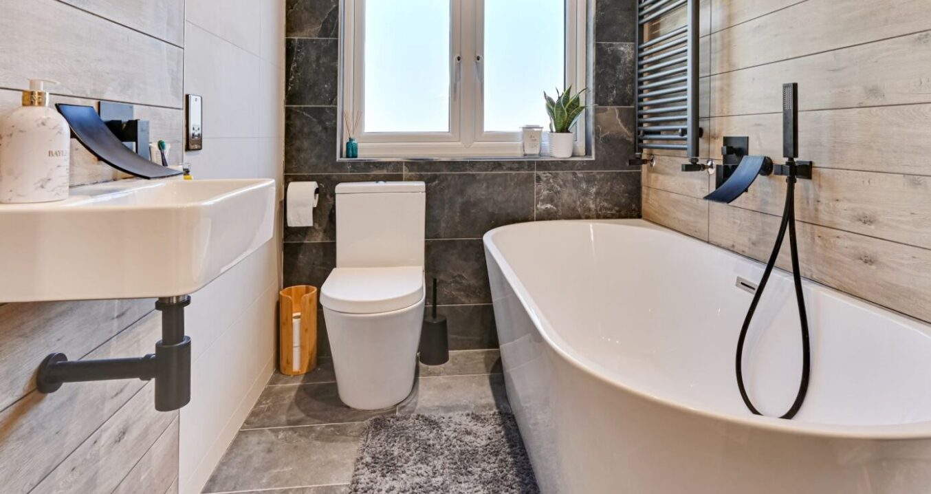 Family bathroom in a Beckenham BR3 loft conversion with bath, modern tiles, black fittings and window