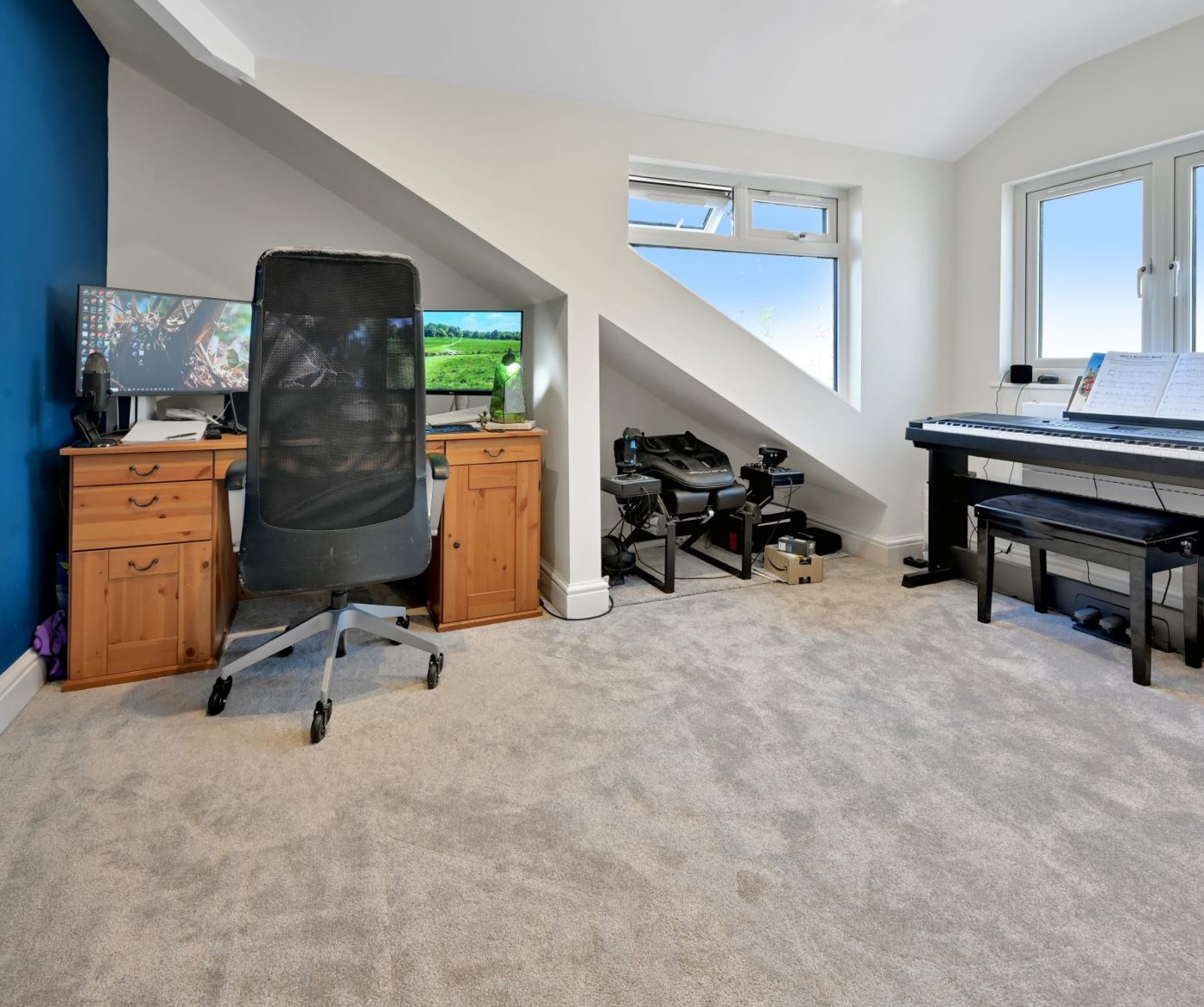 Home office loft room in Beckenham BR3 with desk, chair, piano, roof window and sloping ceiling