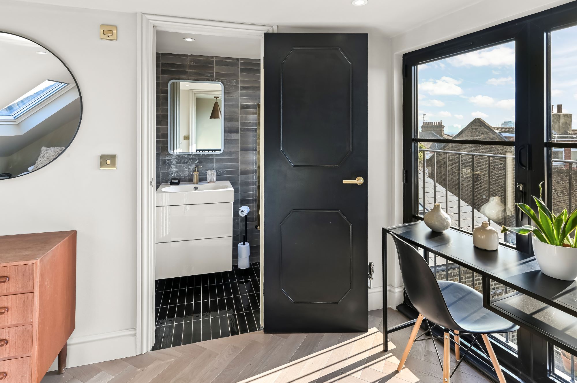 Loft study space in Beckenham BR3 with desk, black framed doors, en suite entrance and roof window
