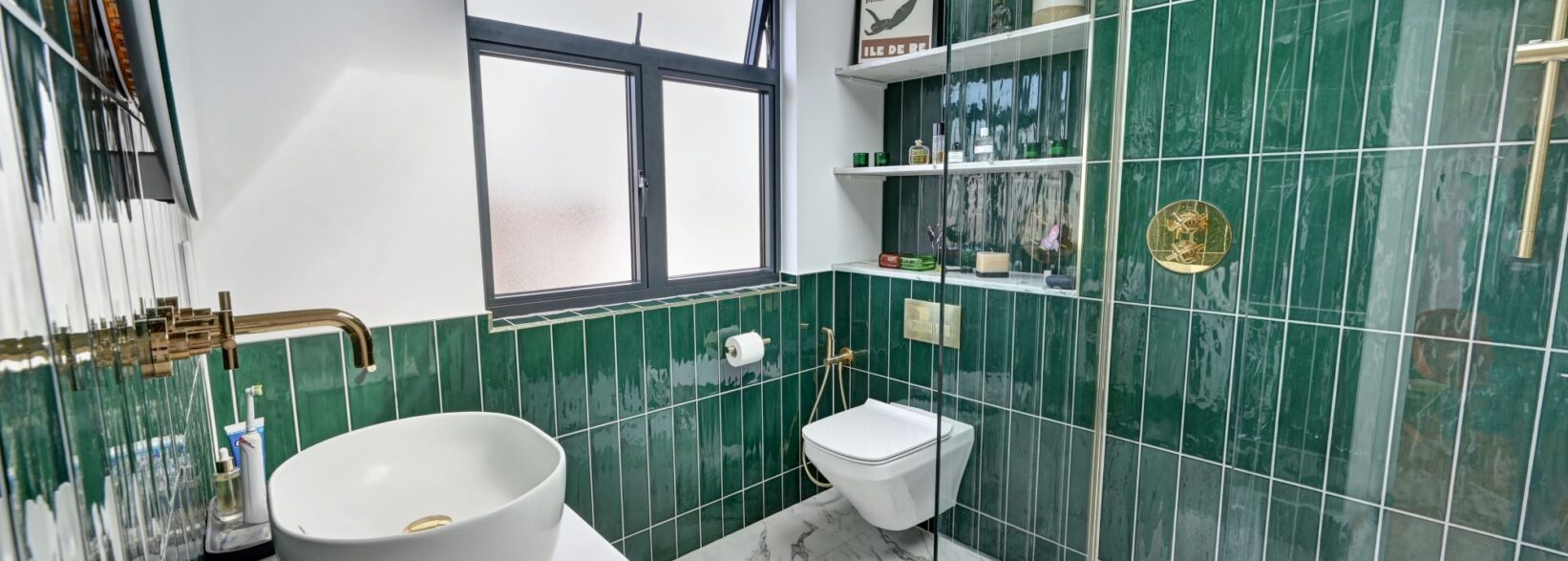 Loft conversion en suite bathroom in Bexleyheath with green tiles, walk-in shower and modern brass fittings