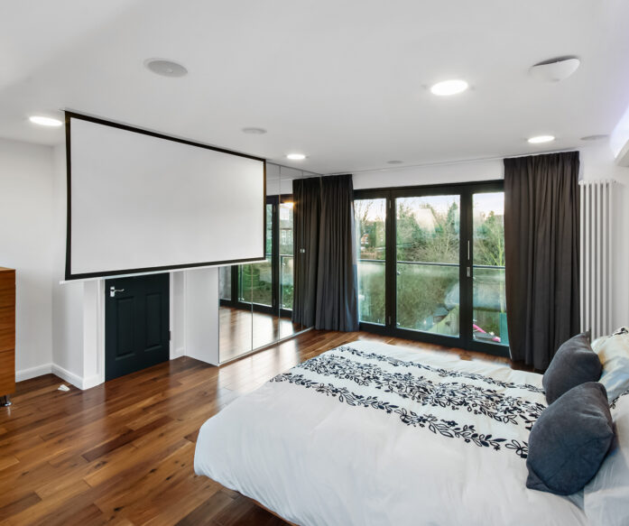 Borehamwood loft conversion bedroom with large doors opening onto a balcony space