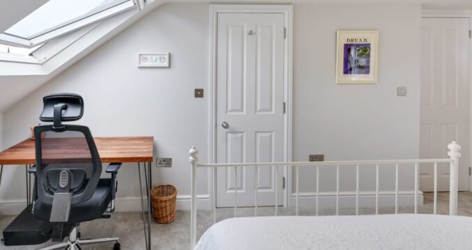 Loft conversion bedroom in Bromley with rooflight window, fitted desk and home office space