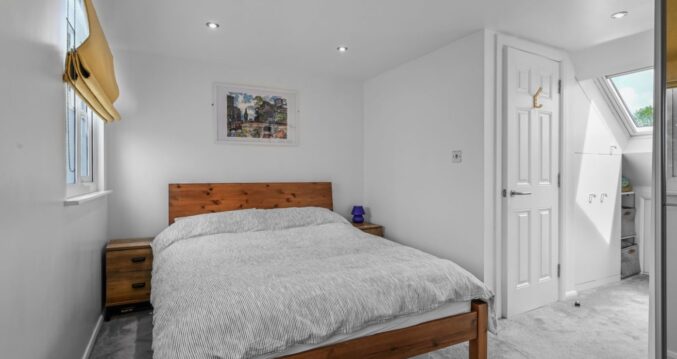 Double bedroom loft conversion in Bromley with grey carpet, white walls and modern fitted layout