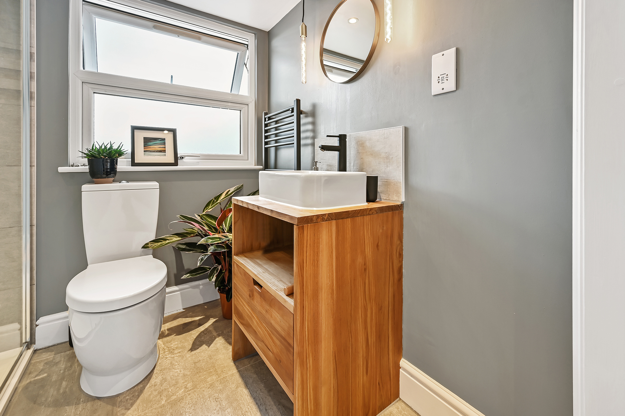 En suite shower room in Bromley loft conversion with timber vanity unit, grey walls and modern fittings