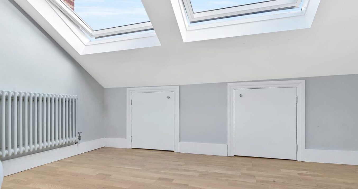 Loft conversion room in Bromley with oak flooring, twin rooflights and built-in eaves storage