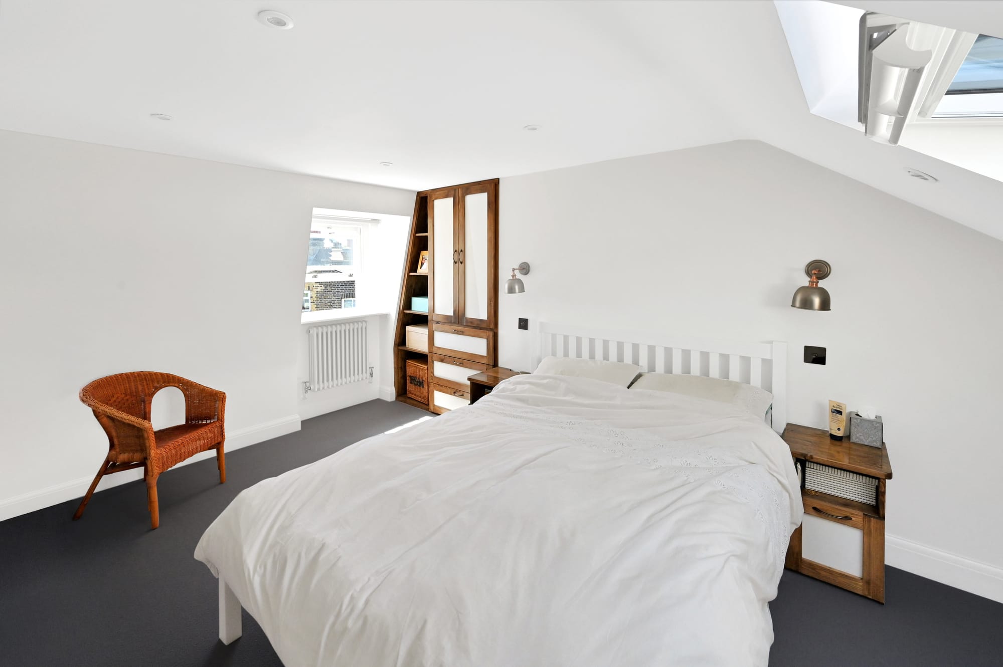 Master bedroom loft conversion in Bromley with fitted wardrobes, sloped ceiling and bespoke built-in storage