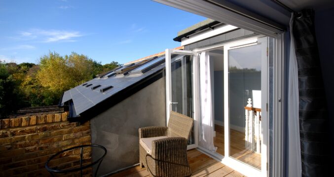 Loft conversion in Bromley with private roof terrace, French doors, timber decking and outdoor seating area