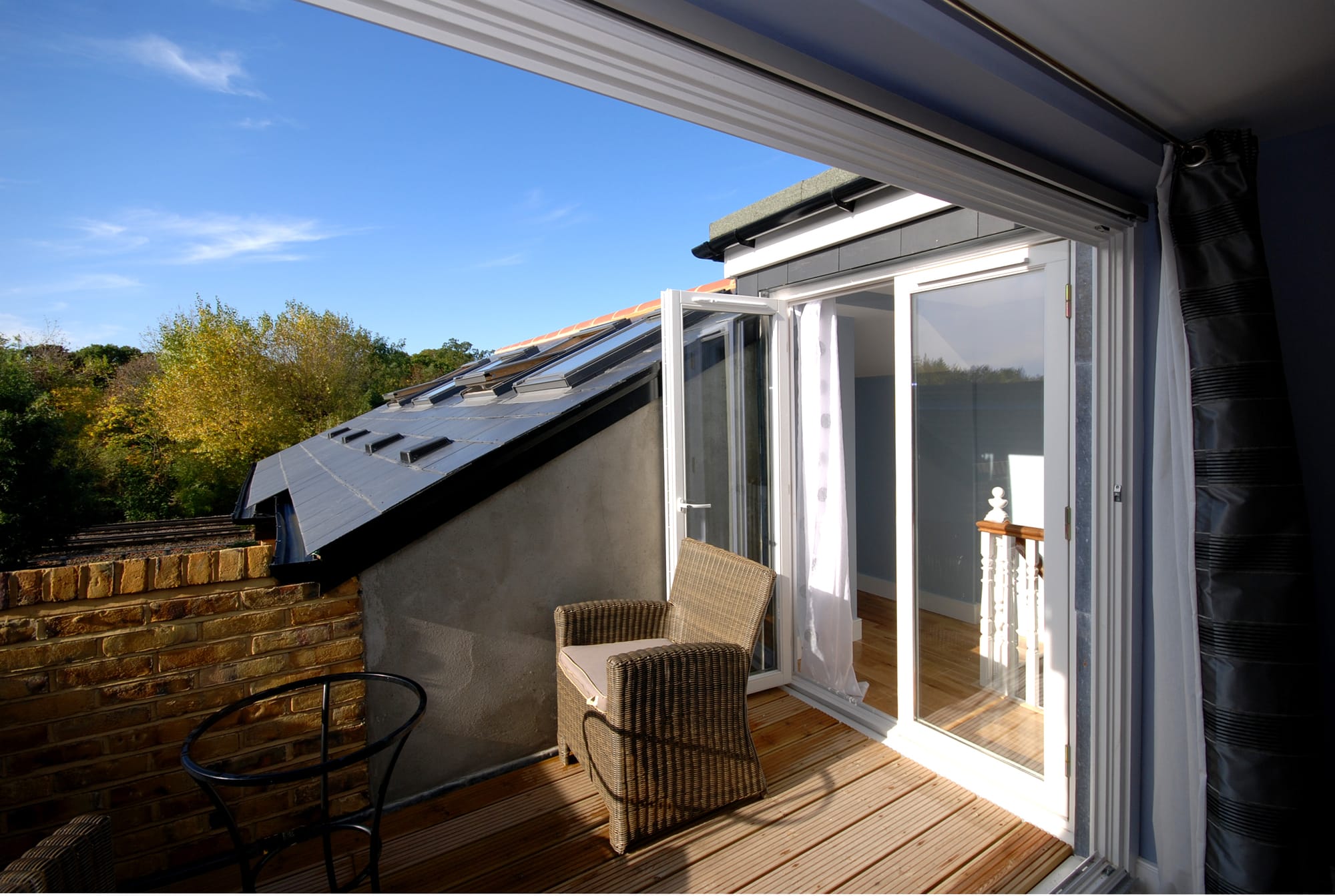 Loft conversion in Bromley with private roof terrace, French doors, timber decking and outdoor seating area