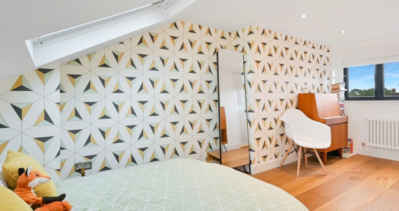 Loft conversion bedroom in Greenwich SE10 with patterned feature wall, rooflight window and bespoke sloped ceiling design