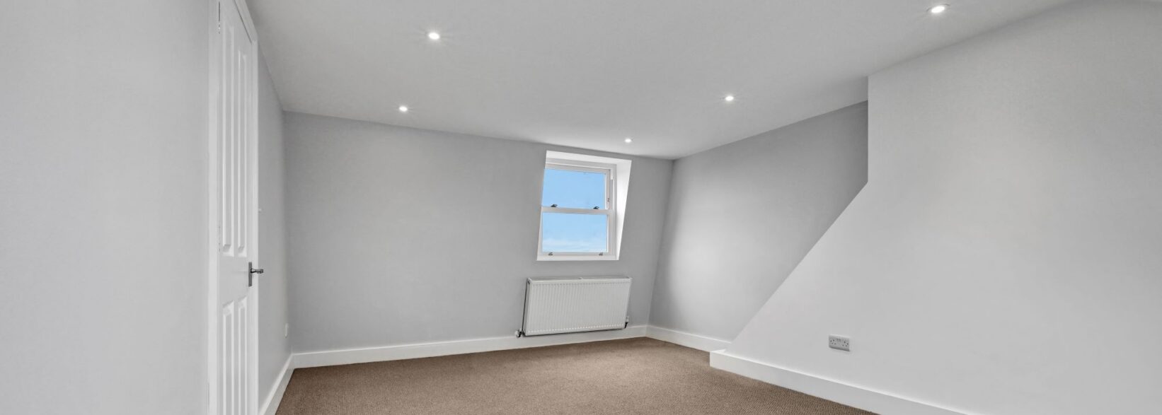Dormer bedroom loft conversion in Mill Hill with grey carpet, recessed lighting and spacious bedroom layout
