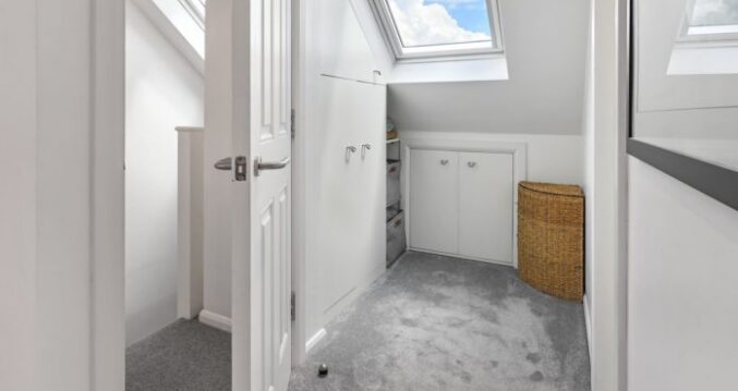 Loft conversion landing in Mill Hill with Velux rooflight, fitted storage cupboards and bright access area