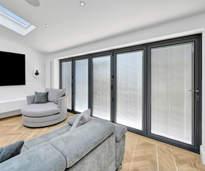 Loft conversion living room in Mill Hill with large glazed doors, rooflight and bright open modern design