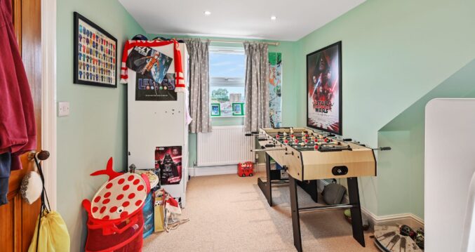 Loft conversion boys bedroom in Sidcup with games table, window and spacious family layout