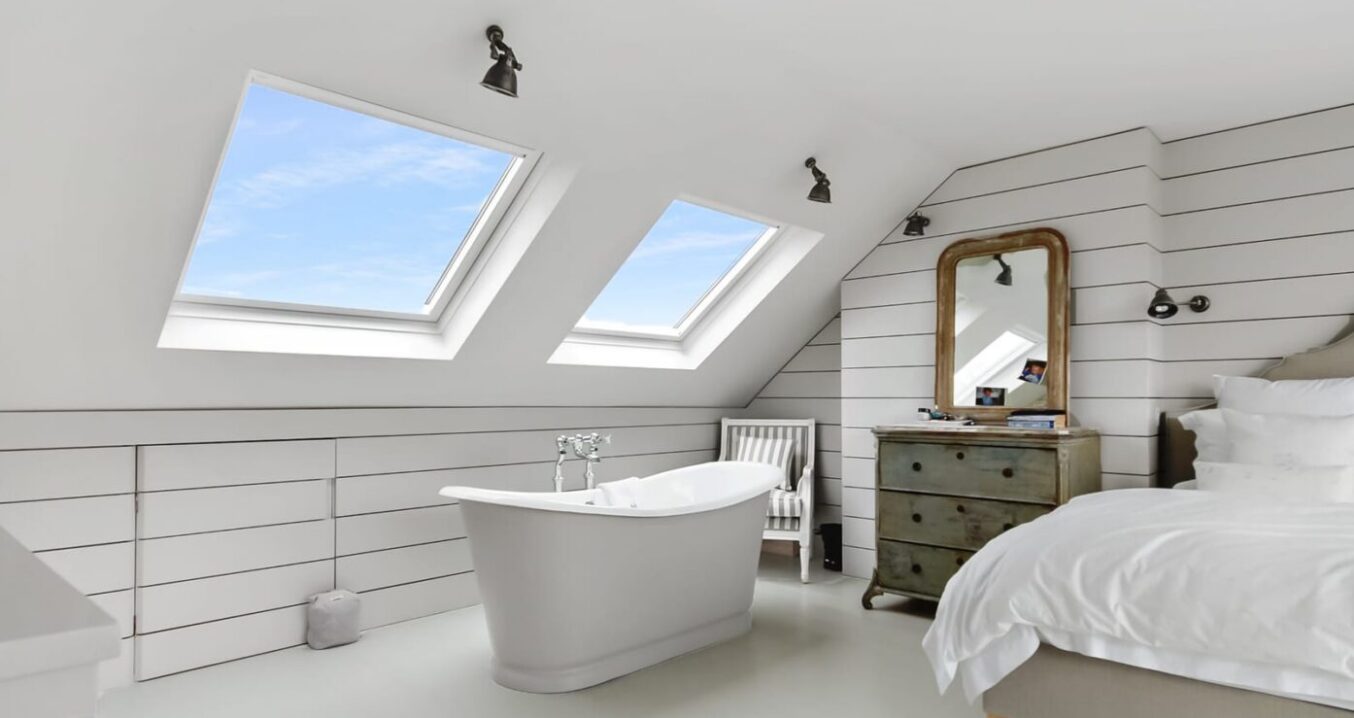 : Loft conversion bedroom in Woolwich with feature bath, rooflights and bespoke wall panelling
