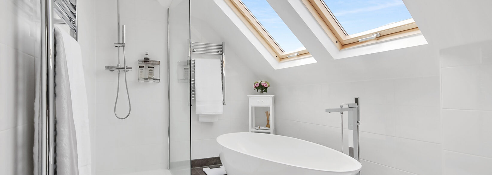 Luxury loft conversion bathroom in Woolwich with freestanding bath, shower enclosure and Velux rooflights