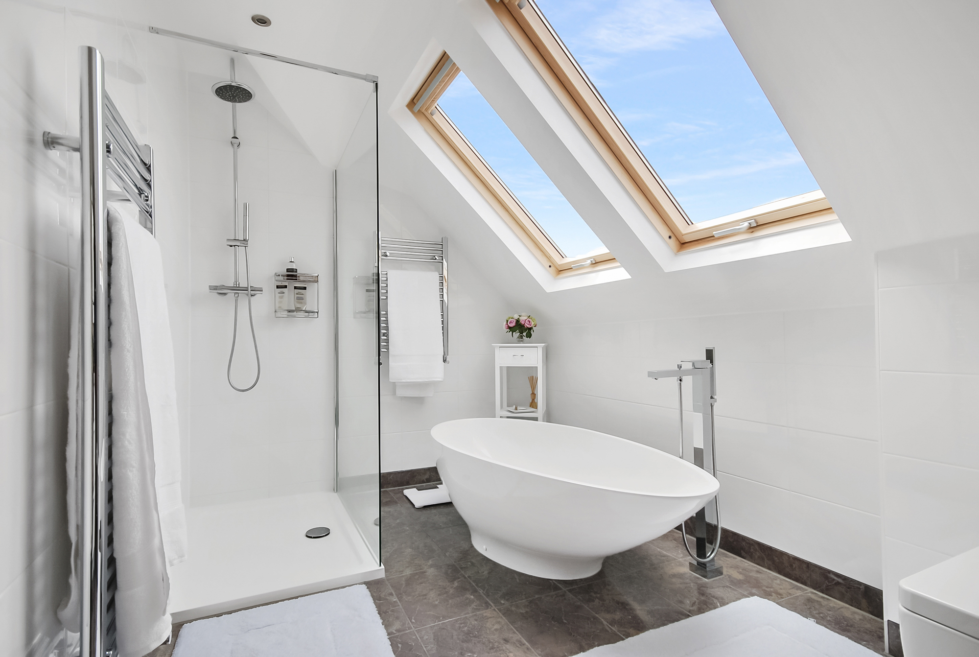 Luxury loft conversion bathroom in Woolwich with freestanding bath, shower enclosure and Velux rooflights
