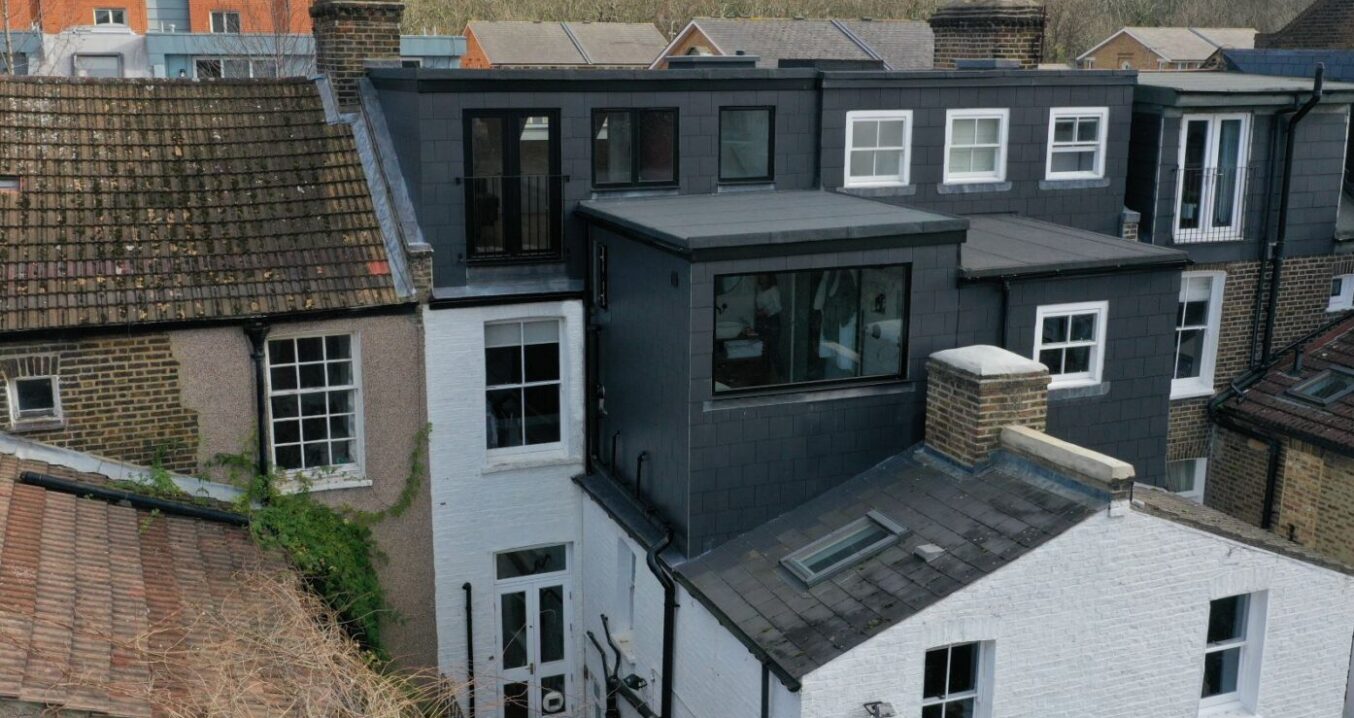 Rear dormer loft conversion in Woolwich with dark slate cladding, Juliet balcony and modern full width loft extension exterior