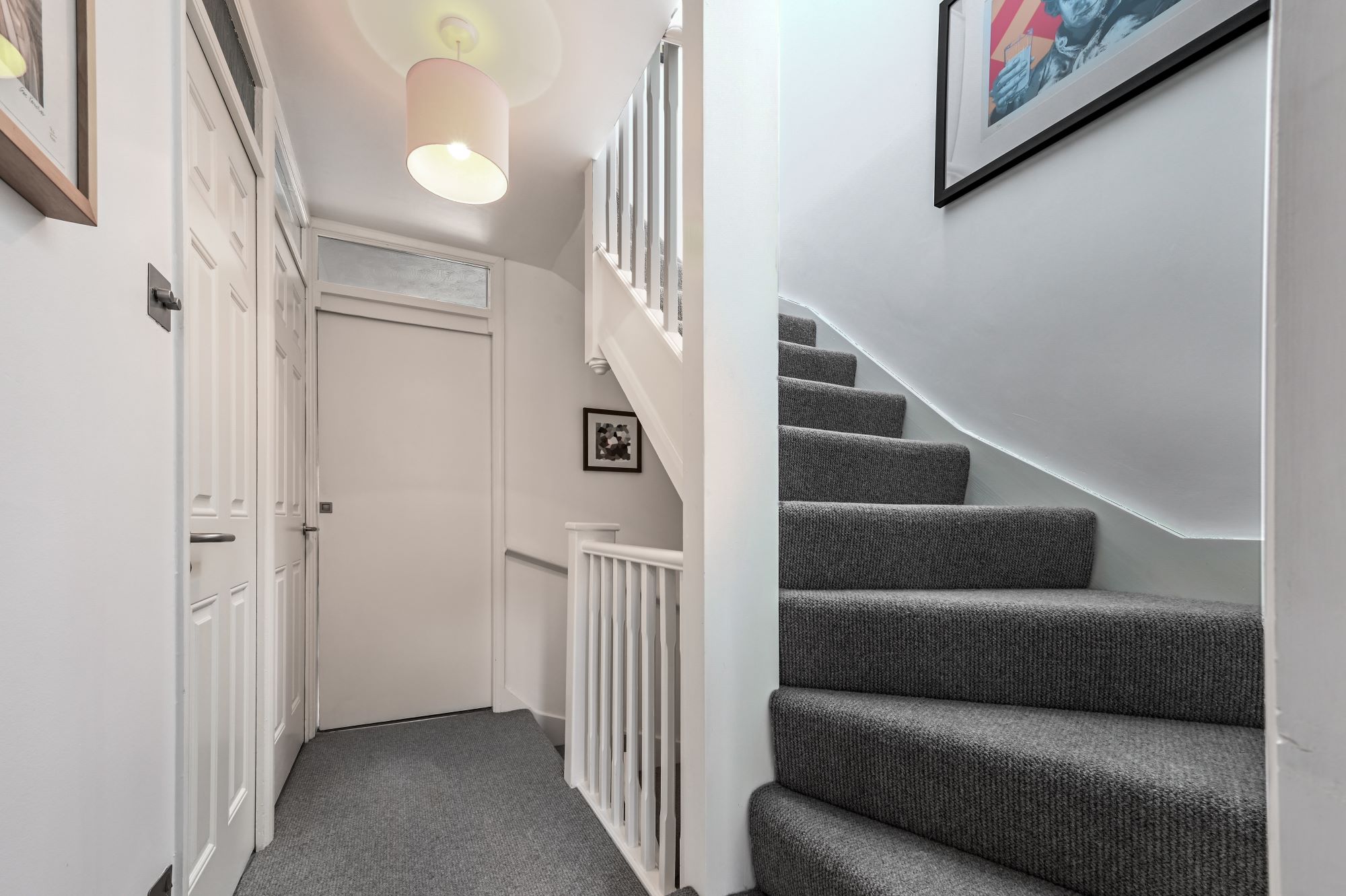 Loft staircase with grey carpet, white spindles and a finished landing, suitable for loft conversion projects in Norwood SE27.