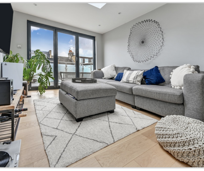 Modern grey sofa living room in Leyton loft conversion with balcony doors.