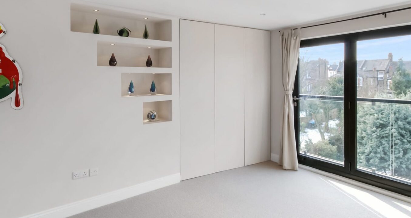 Hip to gable loft conversion modern bedroom in Barnet with bifold doors and full height white wardrobes