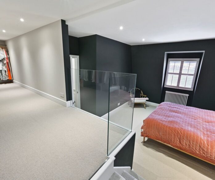 Modern loft bedroom Leytonstone E11 with glass balustrade and dark walls