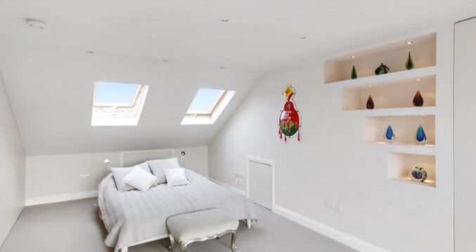 Bright modern loft conversion bedroom featuring hip-to-gable dormer, bifold doors, skylights and built-in shelving in Edgware