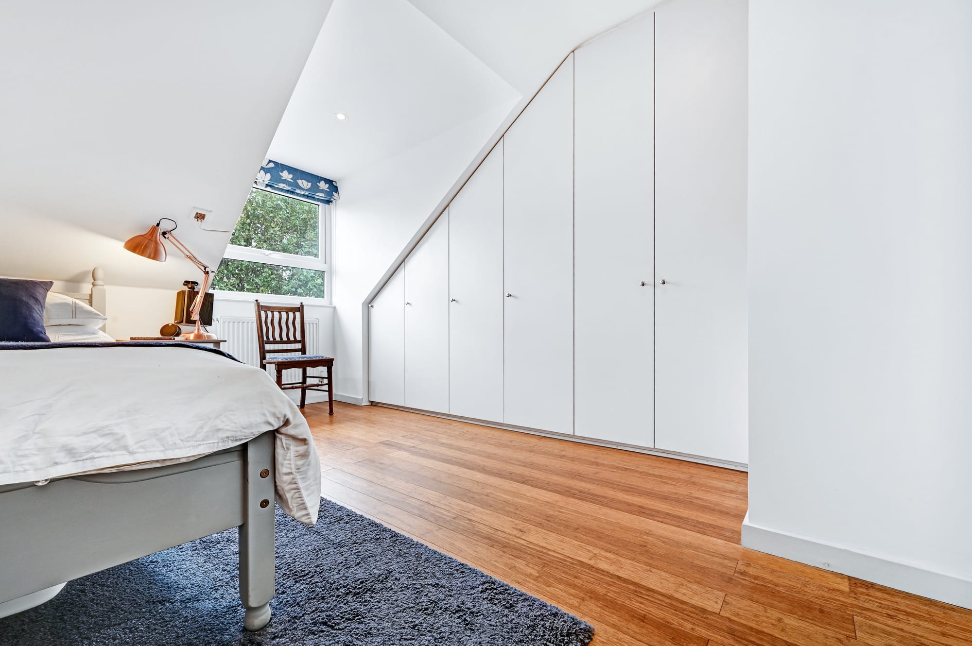 Pitched dormer loft conversion bedroom in Barnet with full height wardrobes and wooden flooring