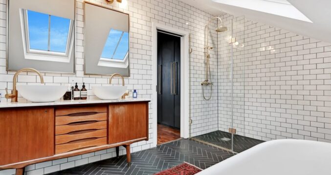 Loft bathroom with roof light, twin basins, feature tiles and freestanding bath for a Plumstead SE18 conversion